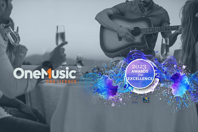 Image description Black and white image of a performer with an acoustic guitar playing to patrons at a restaurant. OneMusic One Licence logo. Purple and Blue ribbons with a circle in the centre that reads: 2023 Awards For Excellence.